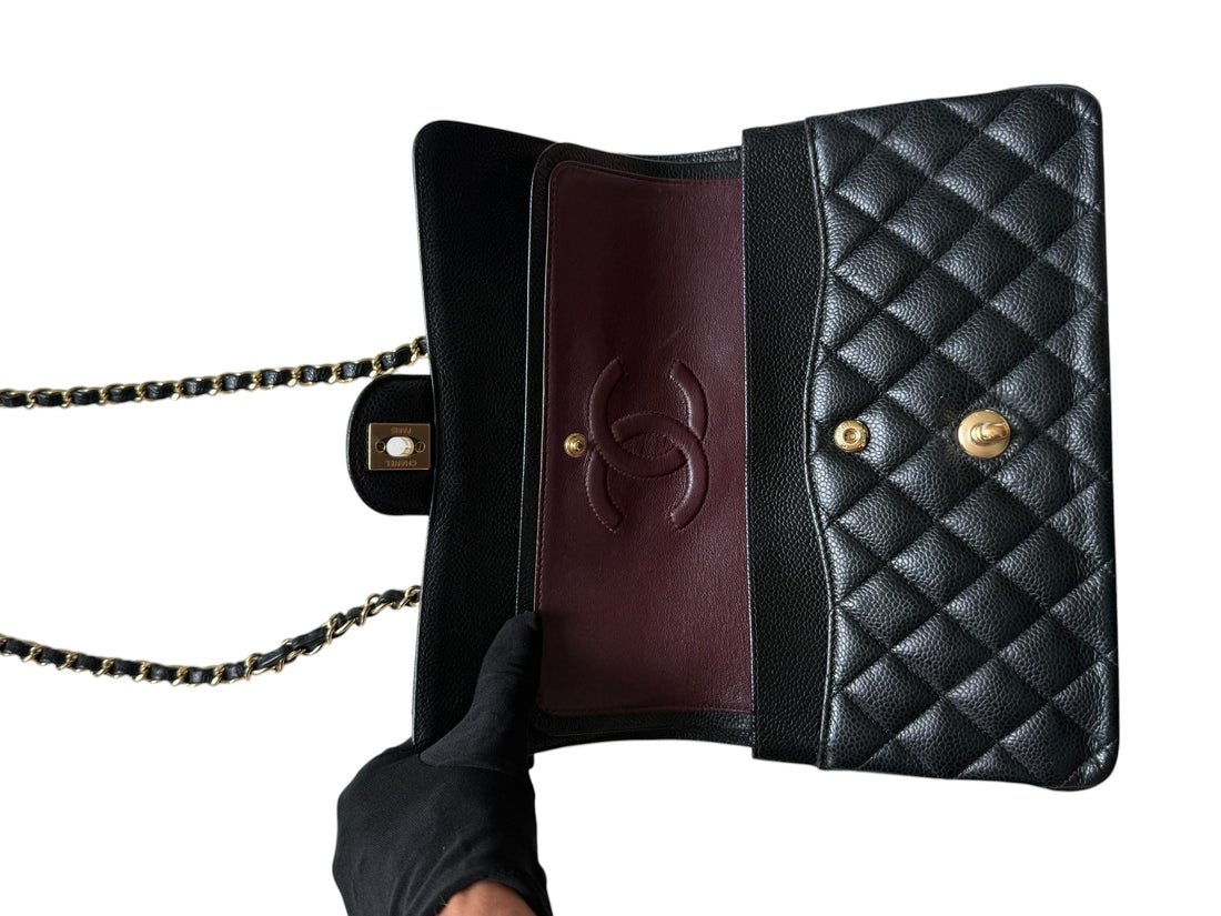 Chanel Medium Classic Double Flap Bag aus schwarzem Caviarleder und goldfarbener Hardware. Bordeauxfarbenes Innenfutter