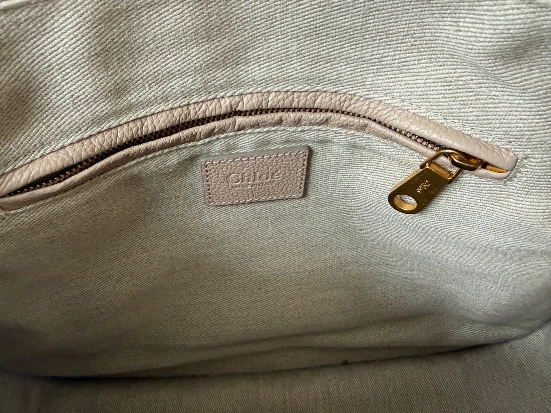 Chloé Marcie Bag in einem santen Nude- bzw. Beigerosa-Ton aus genarbtem Kalbsleder mit charakteristischen handgewickelten Henkeln und goldfarbenen Metallbeschlägen.