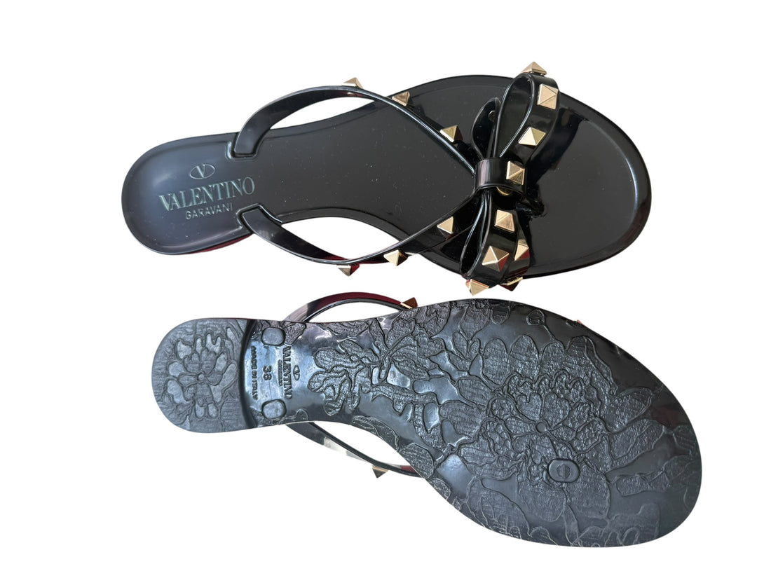Valentino Garavani Rockstud Slipper aus Gummi in Schwarz mit goldfarbenen Nieten und Schleifendetails.