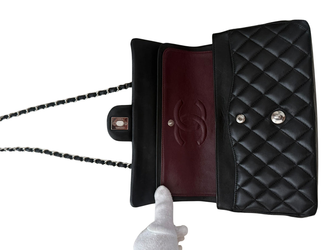 CHANEL Medium Classic Double Flap Bag aus schwarzem Lammleder und silberfarbener Hardware.