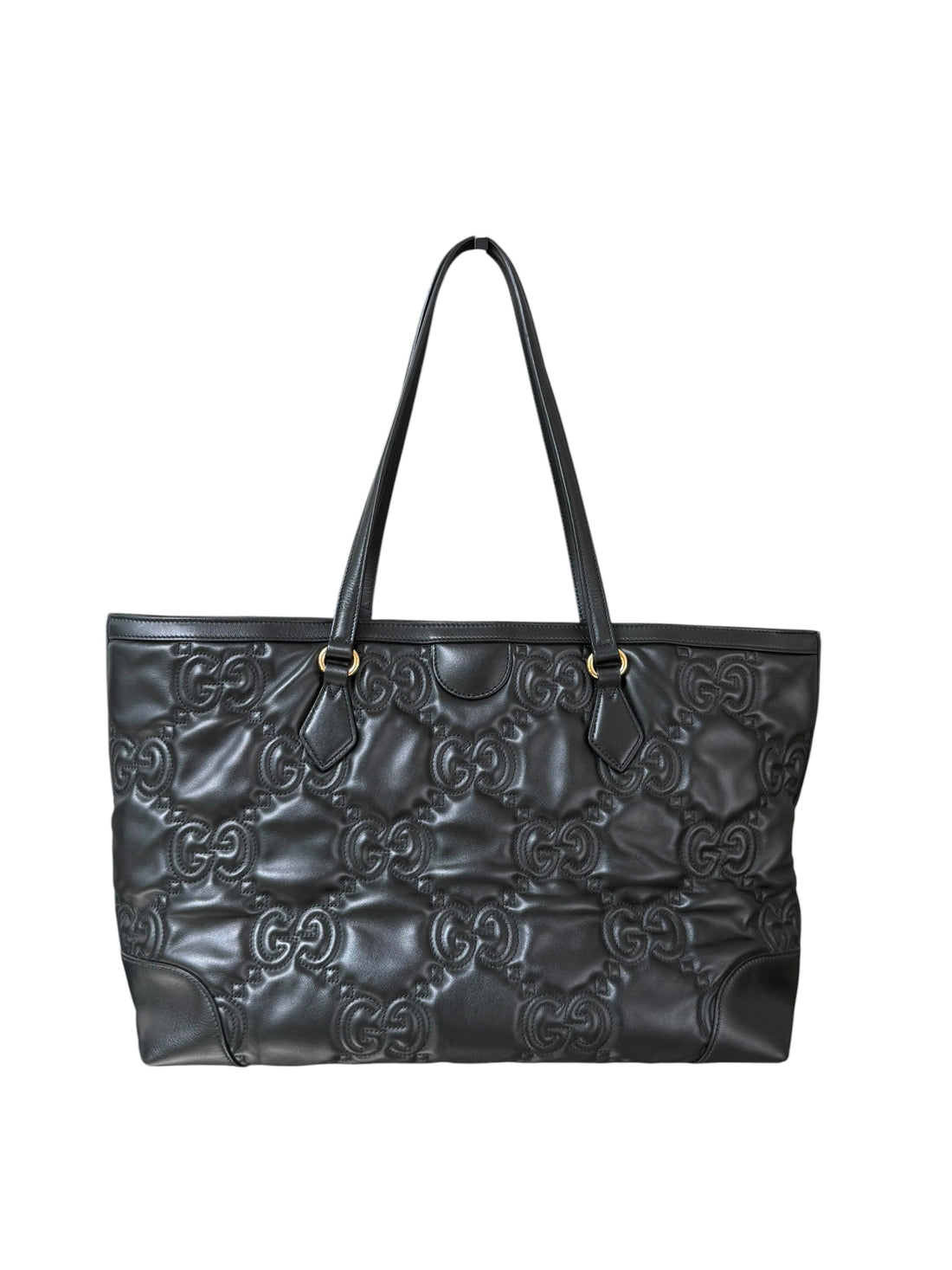Gucci GG Matelassé Tote Bag aus schwarzem Kalbsleder zeichnet sich durch ihre charakteristische Steppung, das ikonische GG-Muster und glänzende, goldfarbene Logo-Details aus.