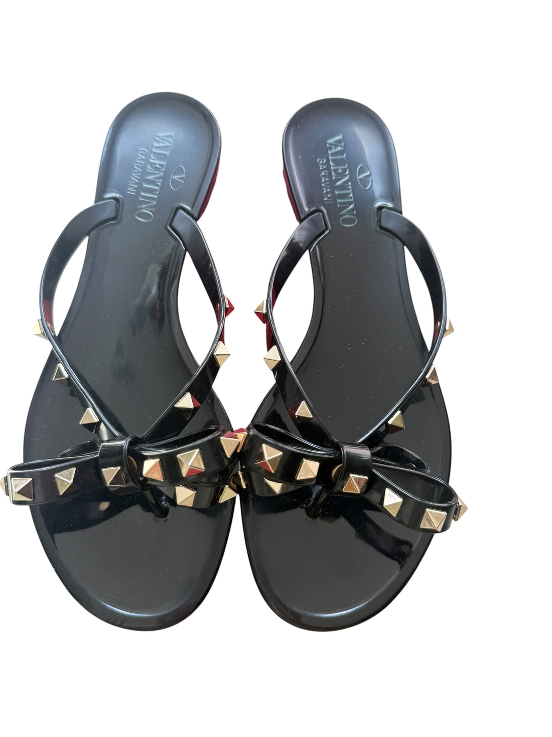 Valentino Garavani Rockstud Slipper aus Gummi in Schwarz mit goldfarbenen Nieten und Schleifendetails.