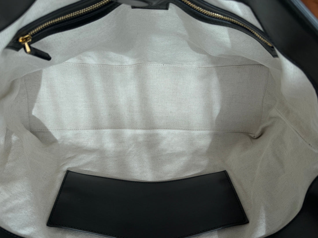 Gucci GG Matelassé Tote Bag aus schwarzem Kalbsleder zeichnet sich durch ihre charakteristische Steppung, das ikonische GG-Muster und glänzende, goldfarbene Logo-Details aus.