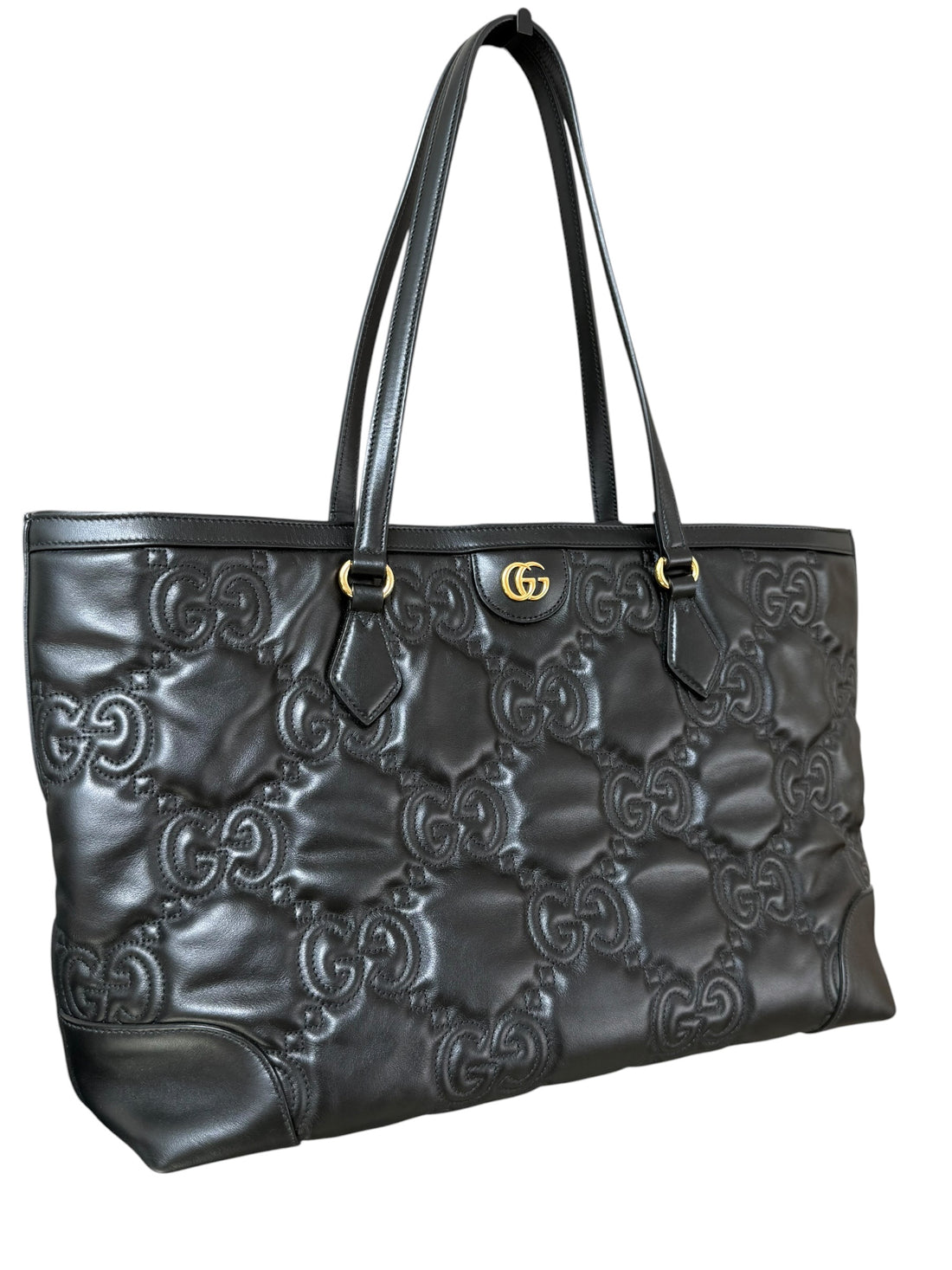 Gucci GG Matelassé Tote Bag aus schwarzem Kalbsleder zeichnet sich durch ihre charakteristische Steppung, das ikonische GG-Muster und glänzende, goldfarbene Logo-Details aus.