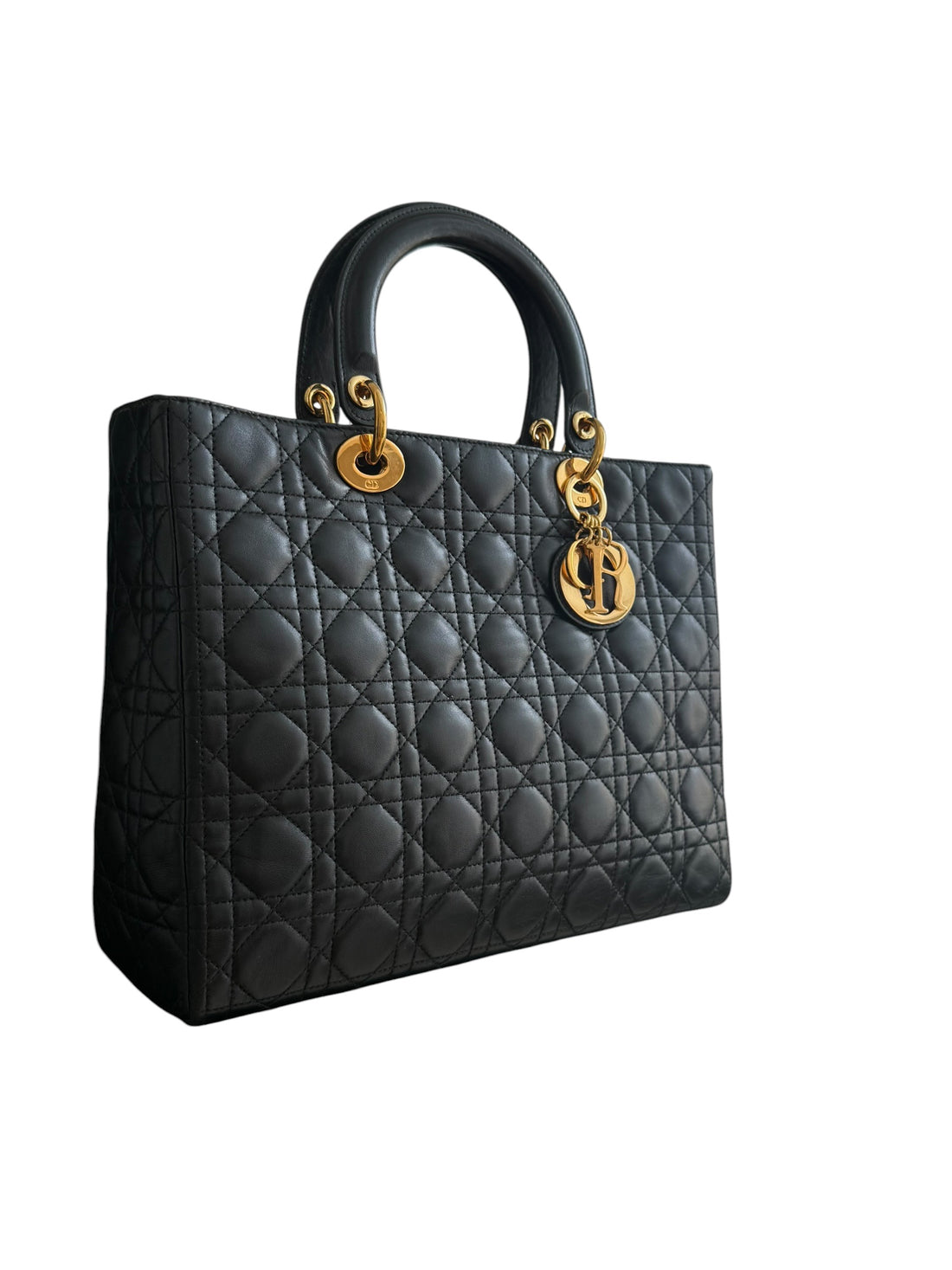 Christian Dior Lady aus schwarzem Lammleder mit Cannage Ziernähten sorgt mit seiner unverkennbaren Steppoptik für einen hohen Wiedererkennungswert. D.I.O.R. Metallanhänger mit Gold-Finish
