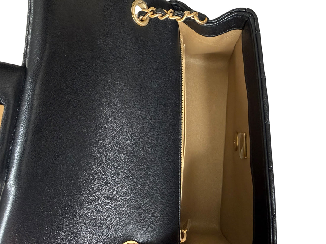 Chanel Pearl Crush Mini Flap Bag ist aus schwarzem Lammleder und zeichnet sich durch goldene Hardware sowie eine verstellbare Kette mit einer ikonischen Perlenkugel aus.