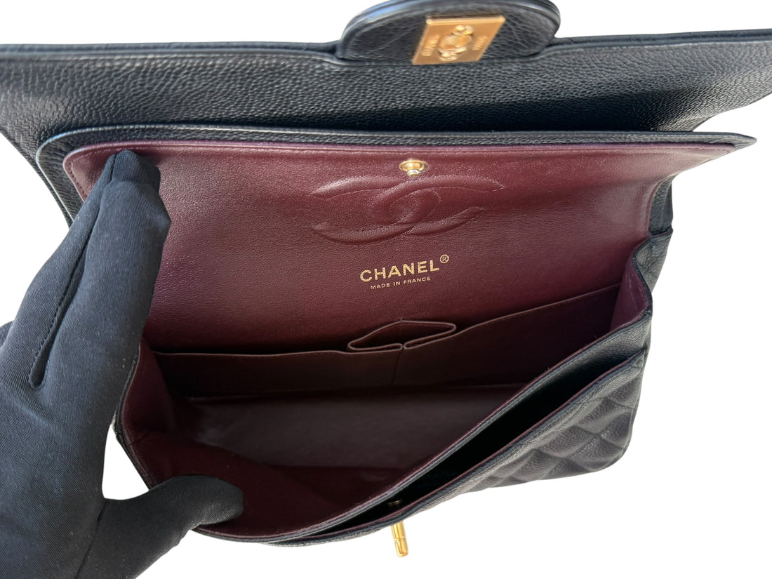 Chanel Classic Timeless Double Flap Bag Medium aus schwarzem Caviarleder und goldfarbener Hardware. Bordeauxfarbenes Innenfutter. Masse: 25x16x6,5 cm. Herstellungsjahr 2014. Loveletterfach. 2 Innenfächer. 1 Aussenfach. Sehr guter Zustand. Inklusive Entrup